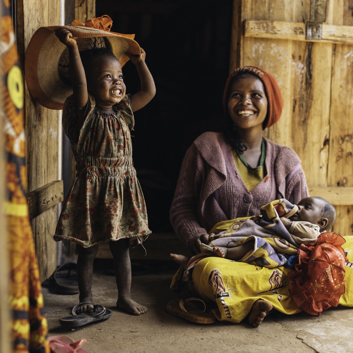 In Madagscar: Eine Mutter und ihre kleinen Kinder auf der Schwelle ihres Hauses