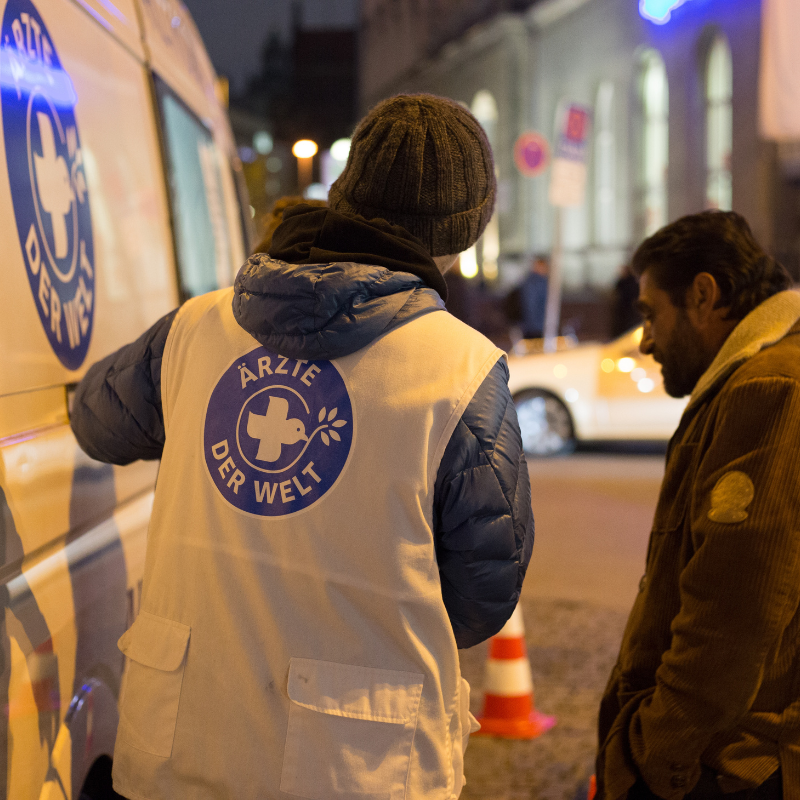 Ein Ehrenamtlicher von Ärzte der Welt spricht mit einer Person, die das Mobile Team in München aufgesucht hat. © Laura Schweizer