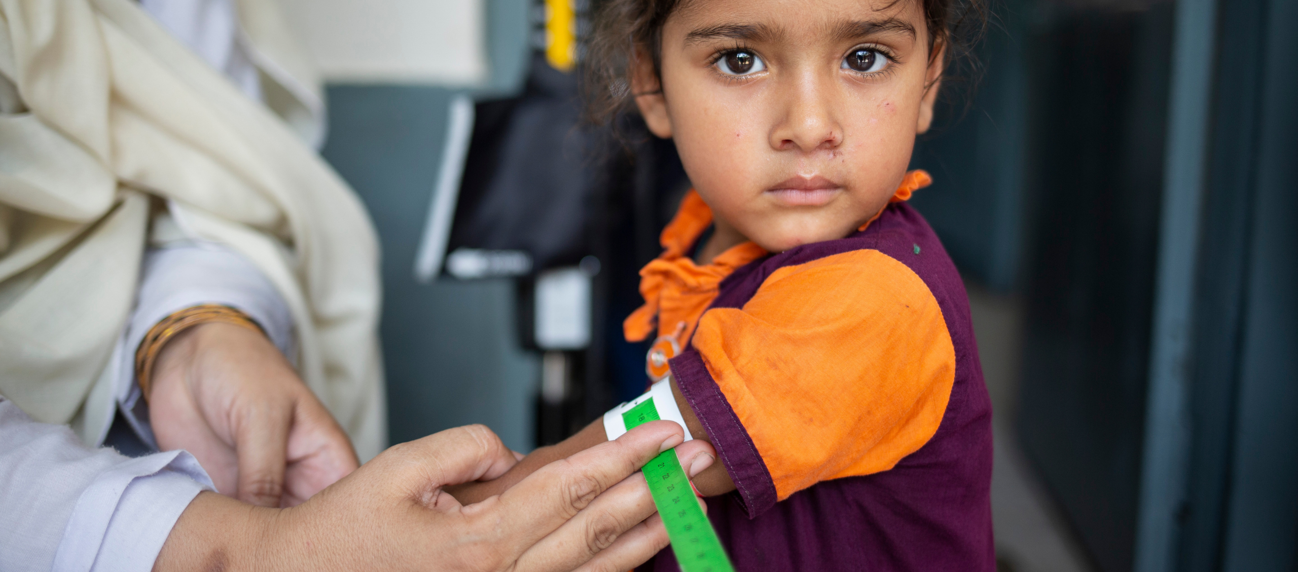 Eine Ärzte der Welt Mitarbeiterin ermittelt mit Hilfe eines MUAC-Bandes den Ernährungszustand eines Mädchens in Pakistan. ©Charsadda Saiyna Bashir
