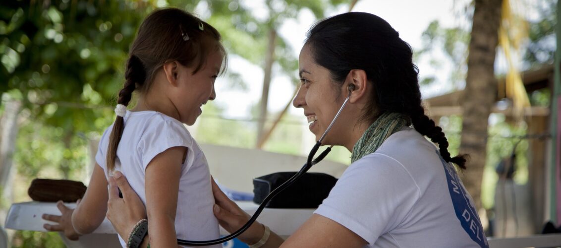 © Berg Andia Ärzte der Welt Mitarbeitende hört ein Kind mit dem Stethoskop ab.