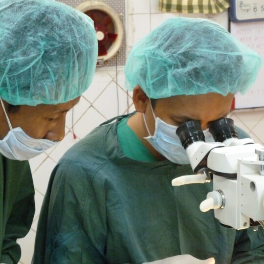 Myanmar: Ärzte untersuchen etwas unter einem Mikroskop. Ärzte der Welt leistet medizinische Hilfe in Myanmar.