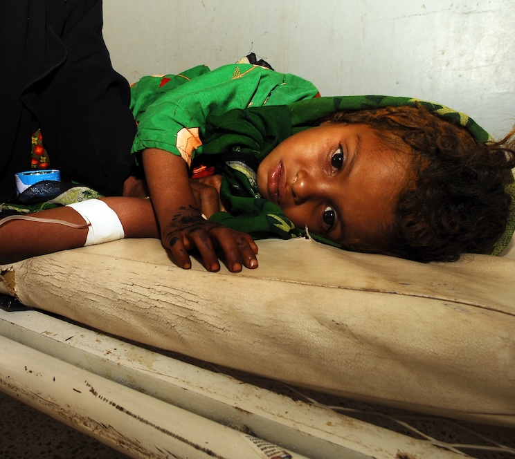 Ein Kind liegt auf einer Liege und erhält Infusionen.