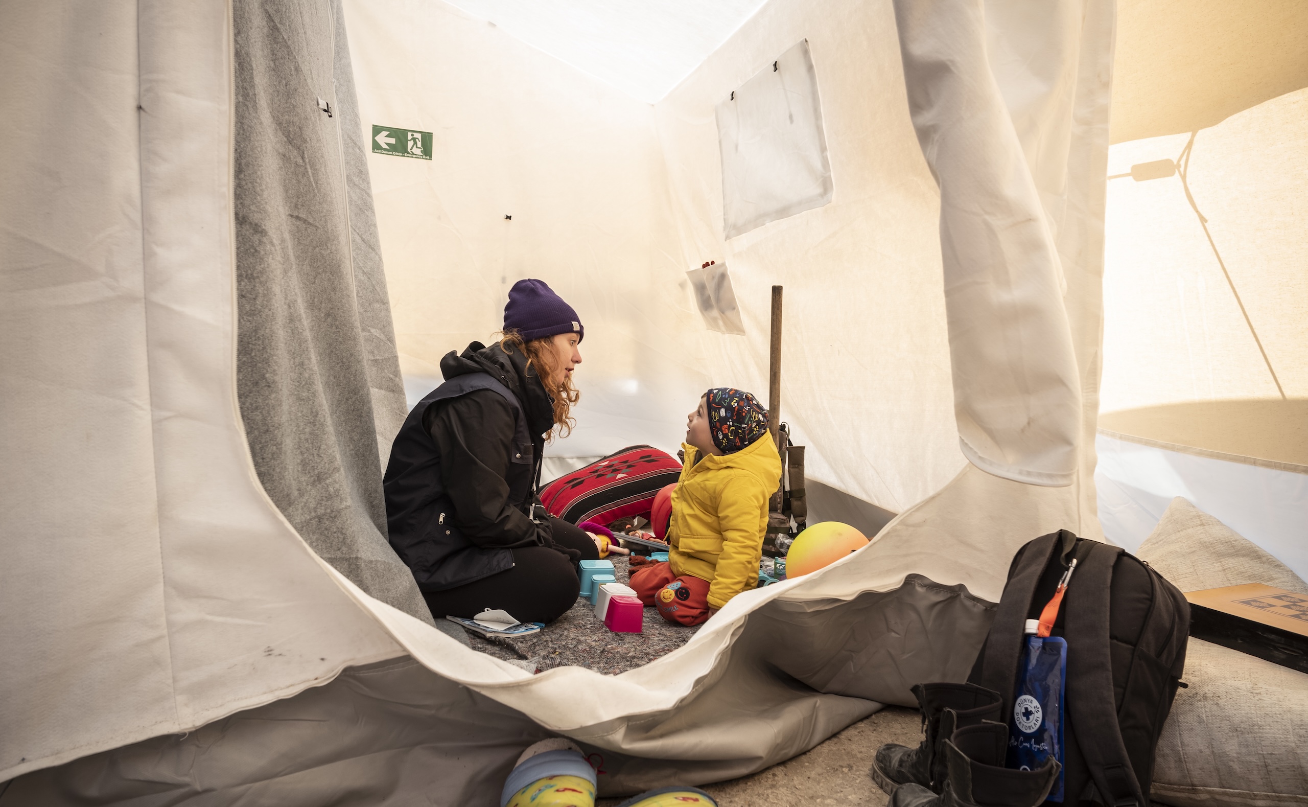 Türkei: Ein Kind und eine Frau sitzen in einem Zelt nach den schweren Erdbeben in der Türkei und Syrien.