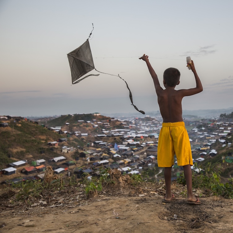 Ein Kind lässt auf einem der Hügel rund um ein Flüchtlingslager in Bangladesch einen Drachen steigen.