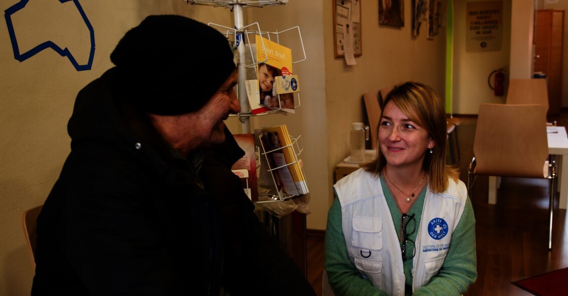 Till Mayer Eine Mitarbeiterin von Ärzte der Welt im Gespräch mit einem Patienten.