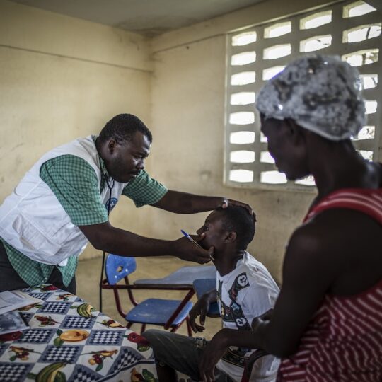 Haiti: Ein Arzt untersucht einen Jungen am Auge.