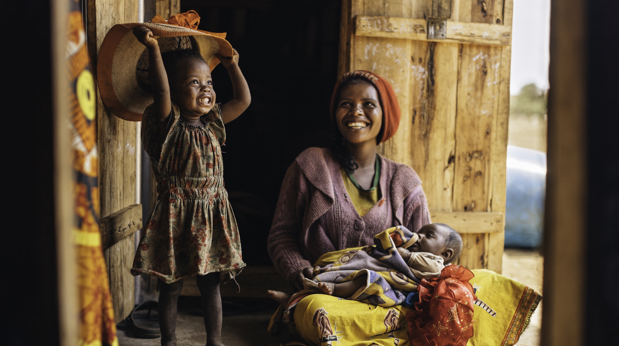 Madagaskar: Eine Frau mit Baby und Kleinkind, lachend. In Madagaskar leistet Ärzte der Welt medizinische Hilfe, u. a. für Mütter und Kinder.