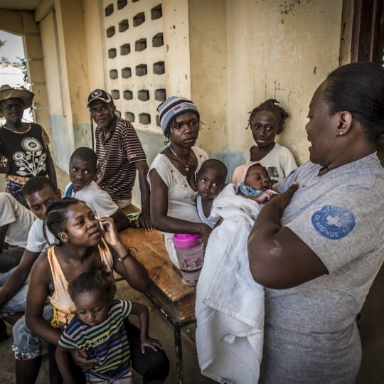 Haiti: Eine Gruppe von Frauen, Männern und Kindern werden beraten von einer Mitarbeiterin von Ärzte der Welt. Ärzte der Welt leistet medizinsiche Hilfe in Haiti.