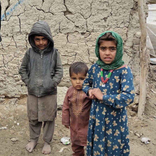 Afghanistan: Drei Kinder stehen vor einem Gebäude in Kabul. Ärzte der Welt leistet medizinische Hilfe in Afghanistan.