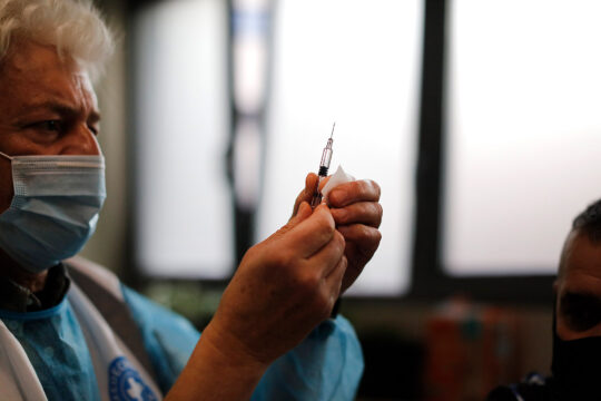 Ein Mitarbeiter von Ärzte der Welt bereitet eine Impfspritze vor.