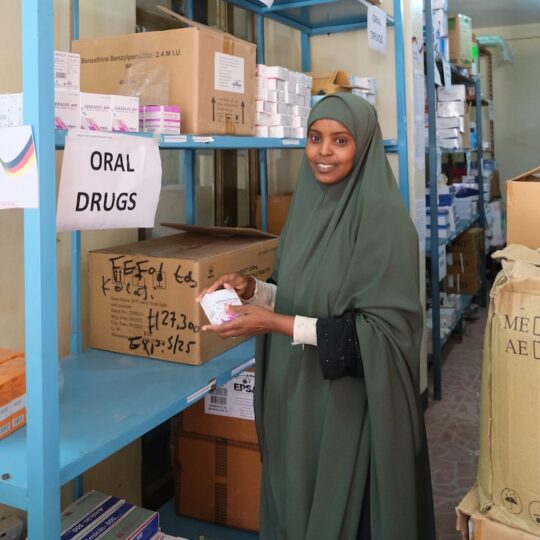 Eine Apothekerin aus Äthiopien steht vor einem Regal mit Medikamenten.