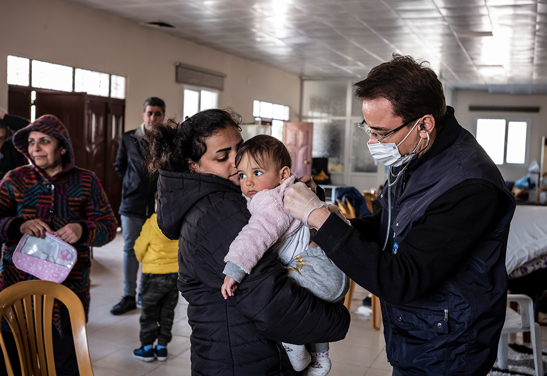 Türkei: Nach dem großen Erdbeben 2023 hört ein Mitarbeiter von Ärzte der Welt ein kleines Kind mit einem Stethoskop ab. © Olivier Papegnies
