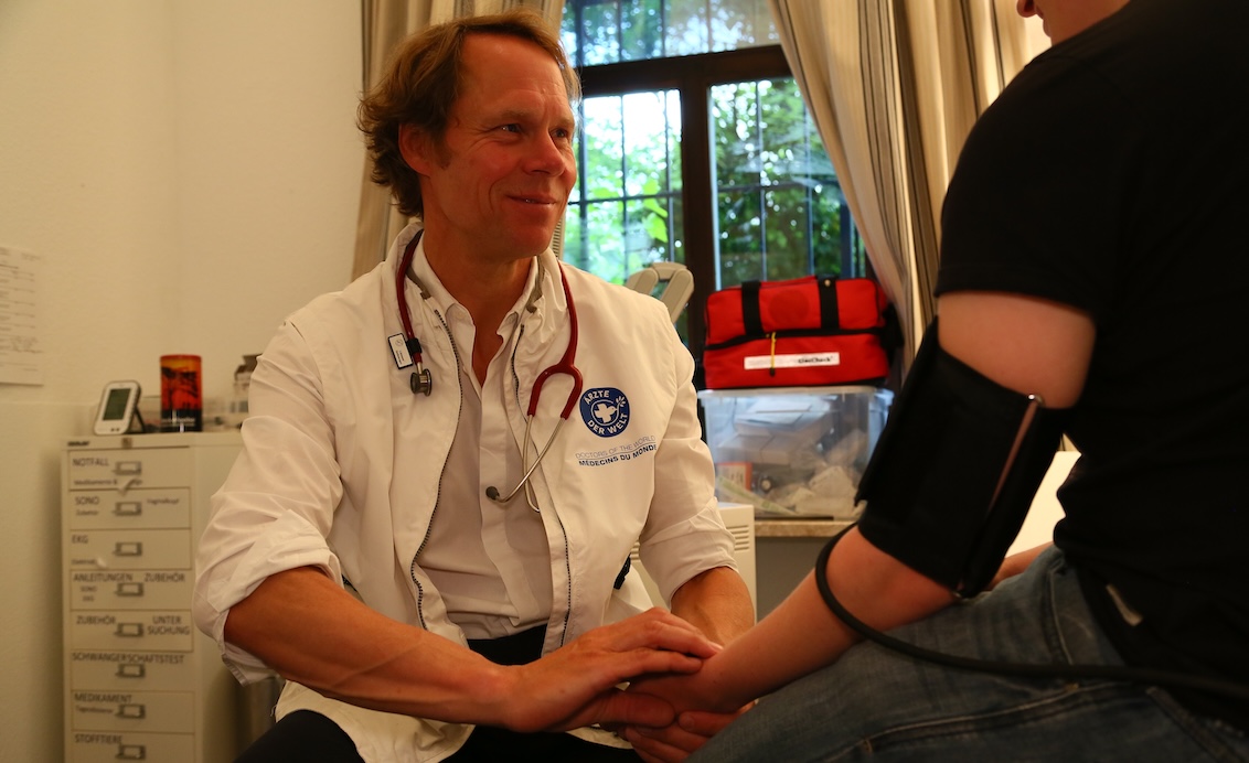 Dr. Peter Schwick misst in unserer open.med Praxis in München den Blutdruck eines Patienten.