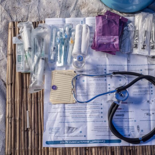 Ein medizinisches Set, unter anderem mit Verbandsmaterial, Spritzen und einem Stethoskop.