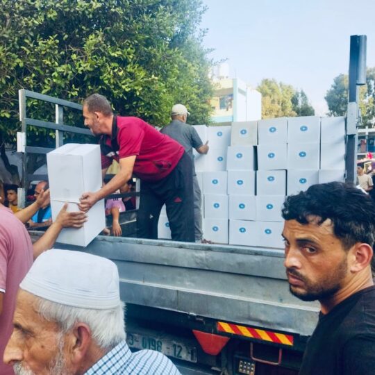 Mehrere Männer laden in Gaza Lieferungen für eine medizinische Unterkunft aus.