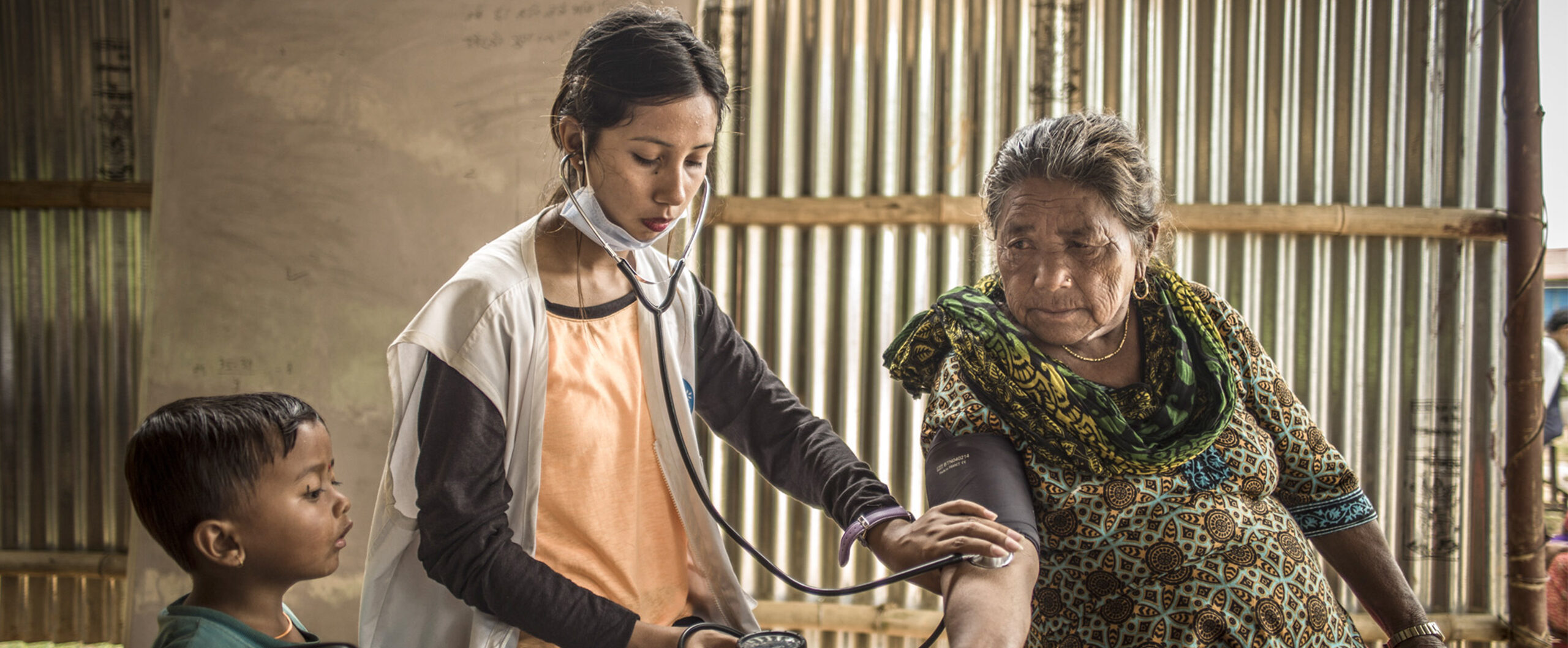 In Nepal misst eine ehrenamtliche Mitarbeiterin den Puls einer Dorfbewohnerin.