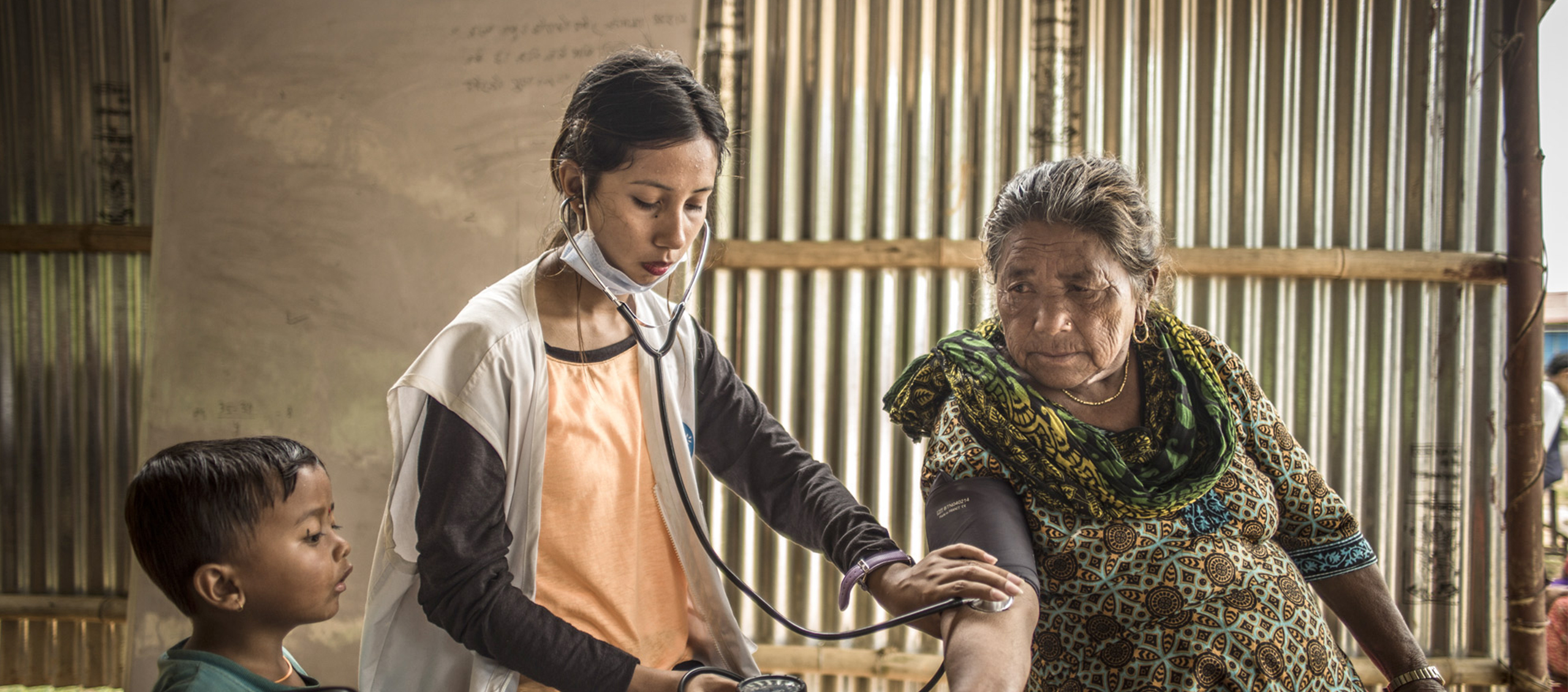 In Nepal misst eine ehrenamtliche Mitarbeiterin den Puls einer Dorfbewohnerin.