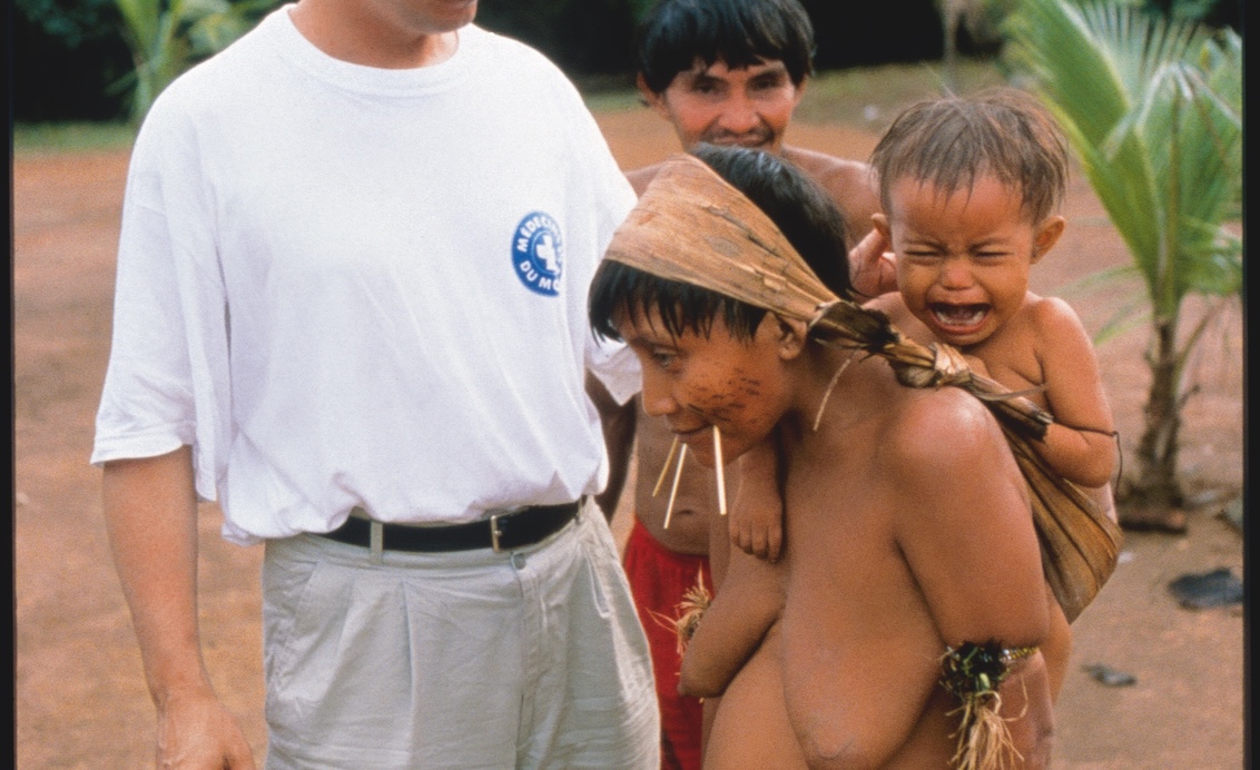 in Arzt des Ärzte der Welt-Teams untersucht ein Kleinkind der ethnischen Gruppe der Yanomami im Amazonasgebiet.