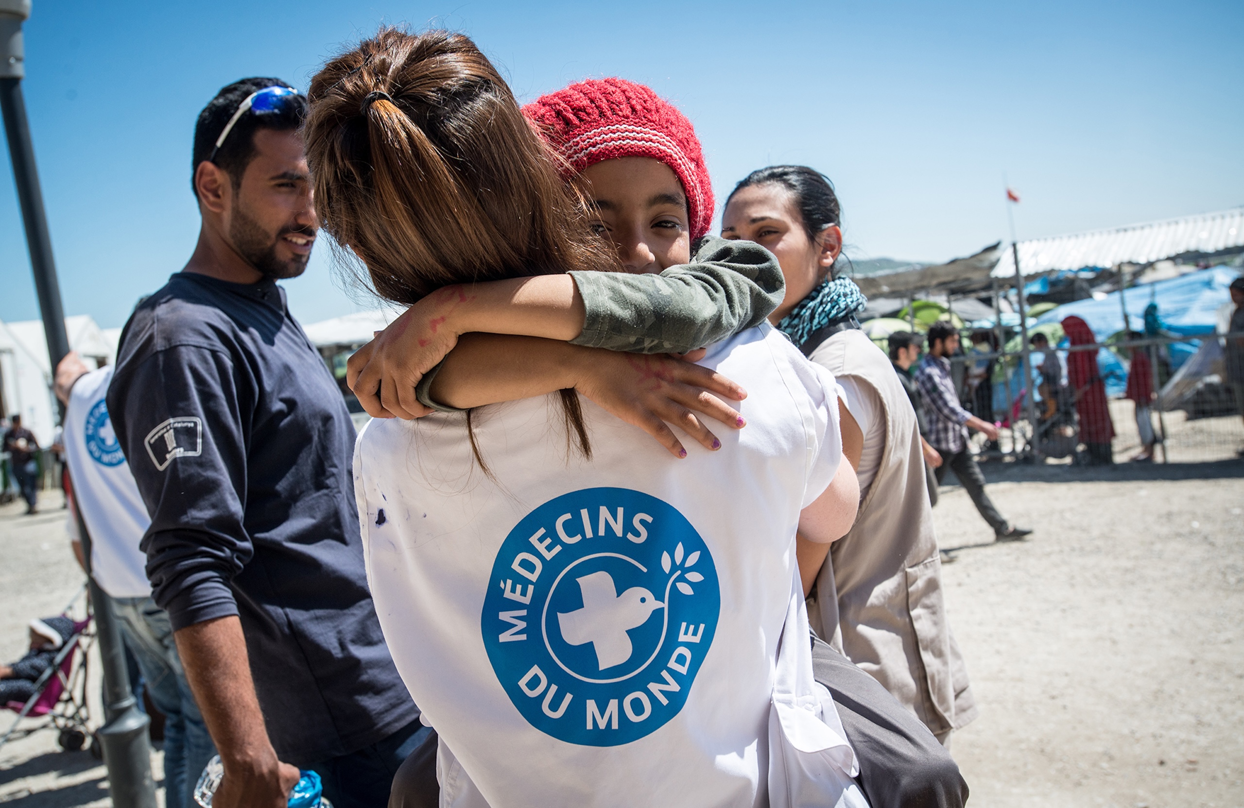 Eine Mitarbeiterin von Ärzte der Welt hält ein Mädchen auf dem Arm.