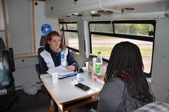Deutschland: Eine Mitarbeiterin von Ärzte der Welt berät eine Frau im Rahmen des reach.out-Projekts. Sie sitzen sich in einem Behandlungsbus von Ärzte der Welt gegenüber. © Ärzte der Welt