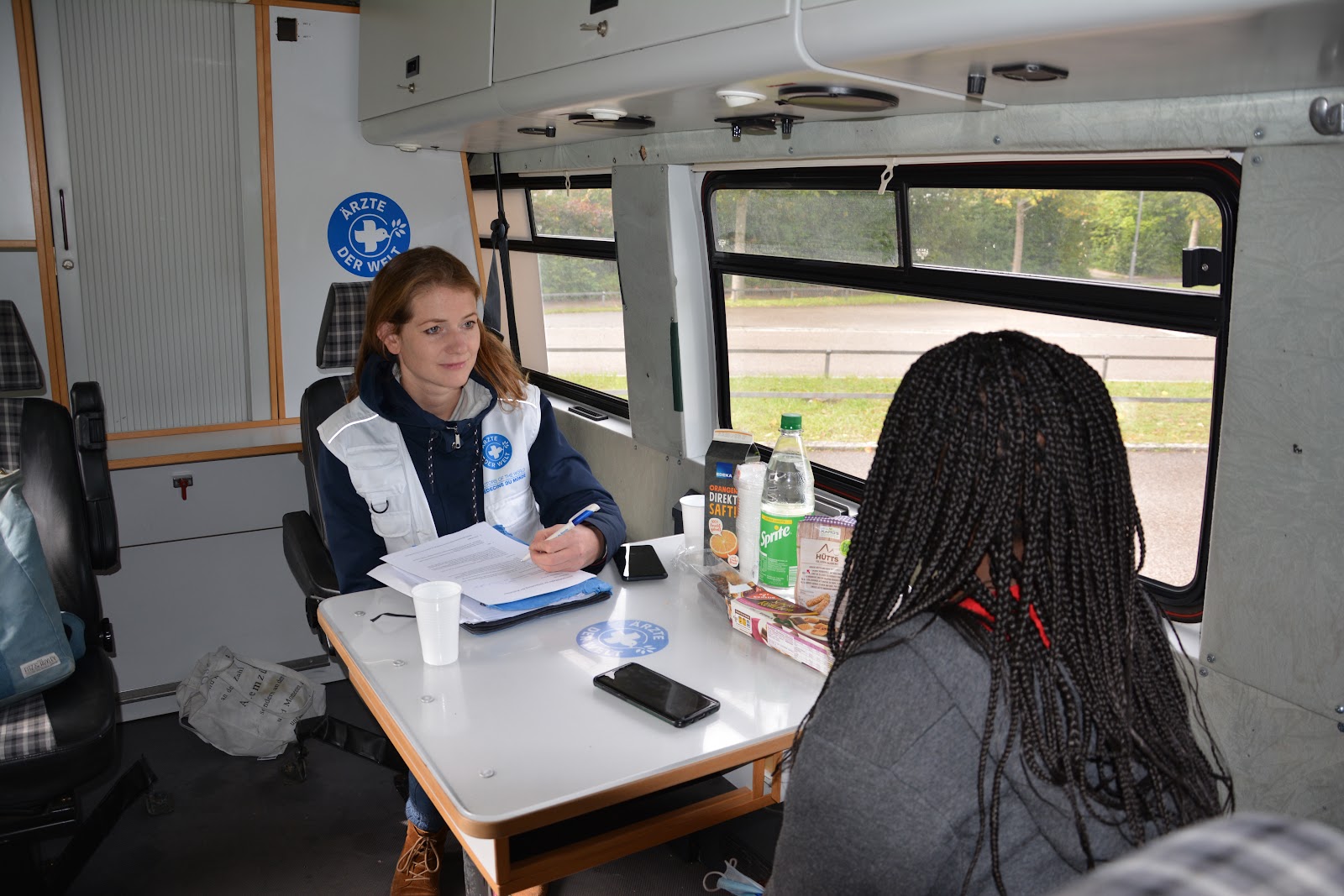 Deutschland: Eine Mitarbeiterin von Ärzte der Welt berät eine Frau im Rahmen des reach.out-Projekts. Sie sitzen sich in einem Behandlungsbus von Ärzte der Welt gegenüber. © Ärzte der Welt