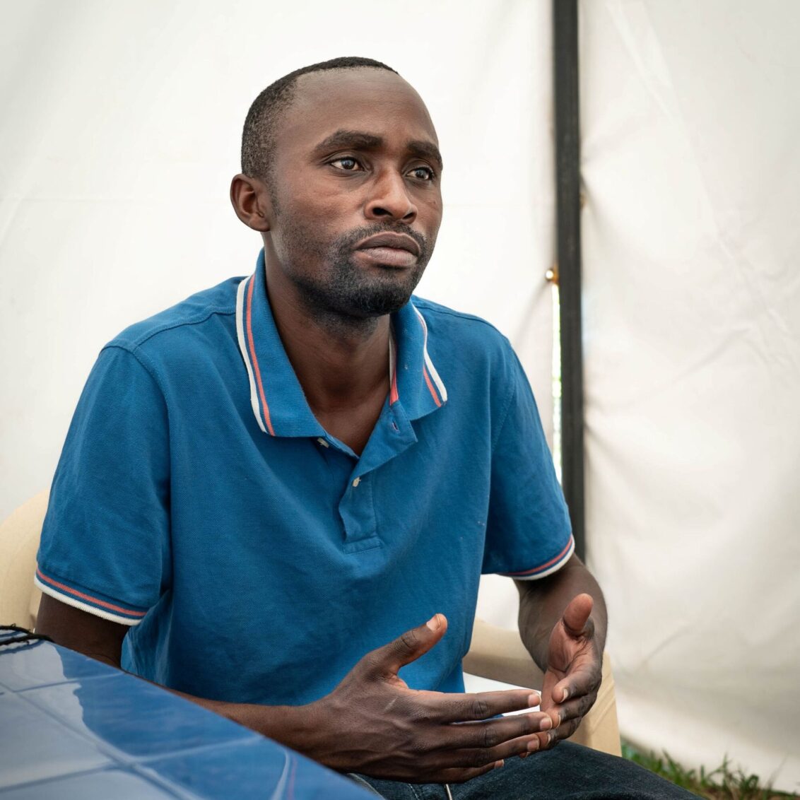 Symbolbild: Ein Mann sitzt in Kongo auf einem Stuhl und guckt in die Ferne.  © Caroline Thirion