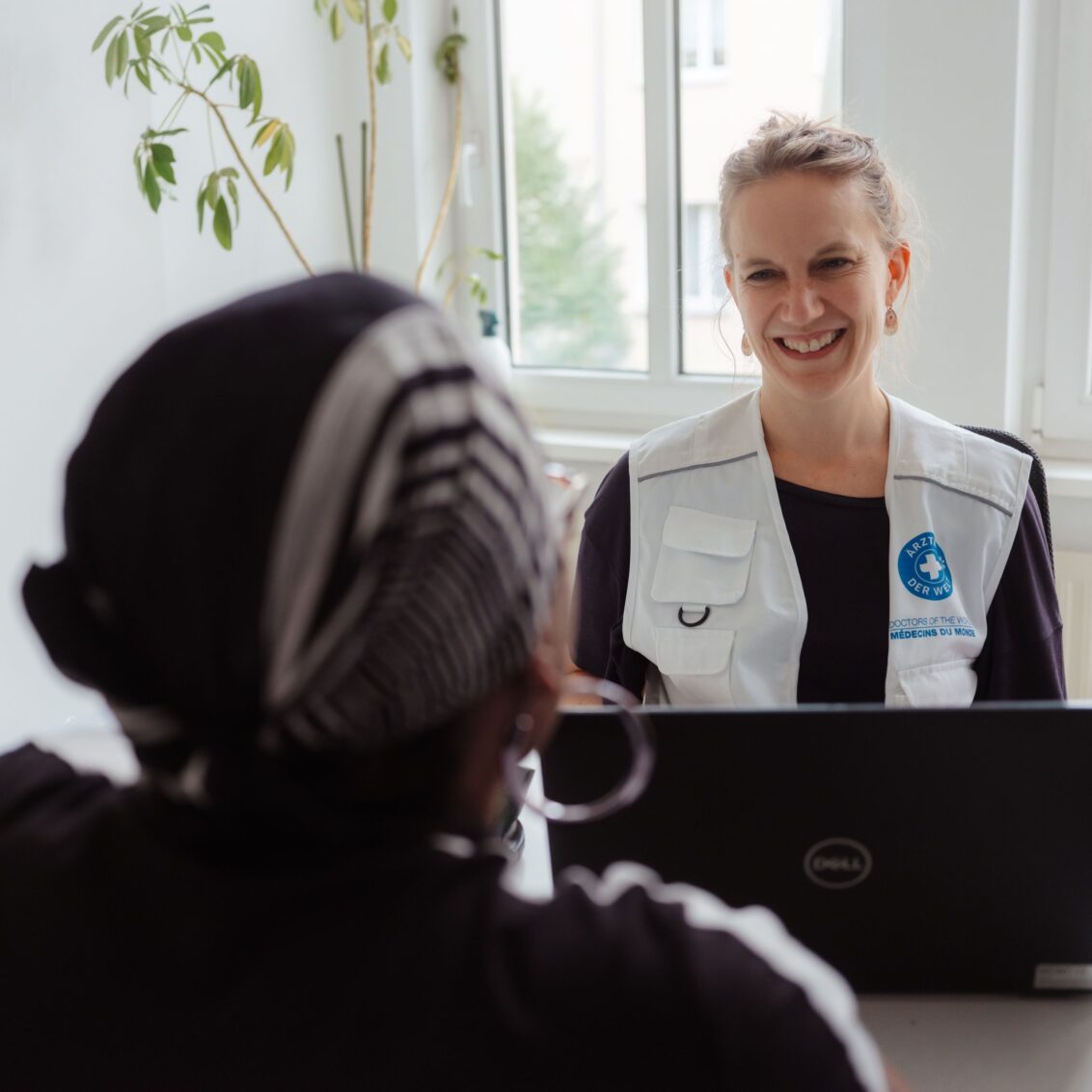 Eine Mitarbeiterin redet mit einer Patientin in einer Sprechstunde der open.med Praxis in Berlin. © Max Avdeev