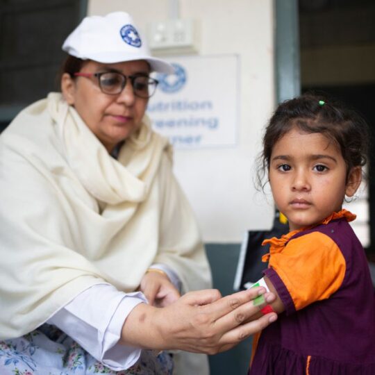 Pakistan: Eine Mitarbeiterin von Ärzte der Welt misst einem Mädchen den Armumfang. © Saiyna Bashir