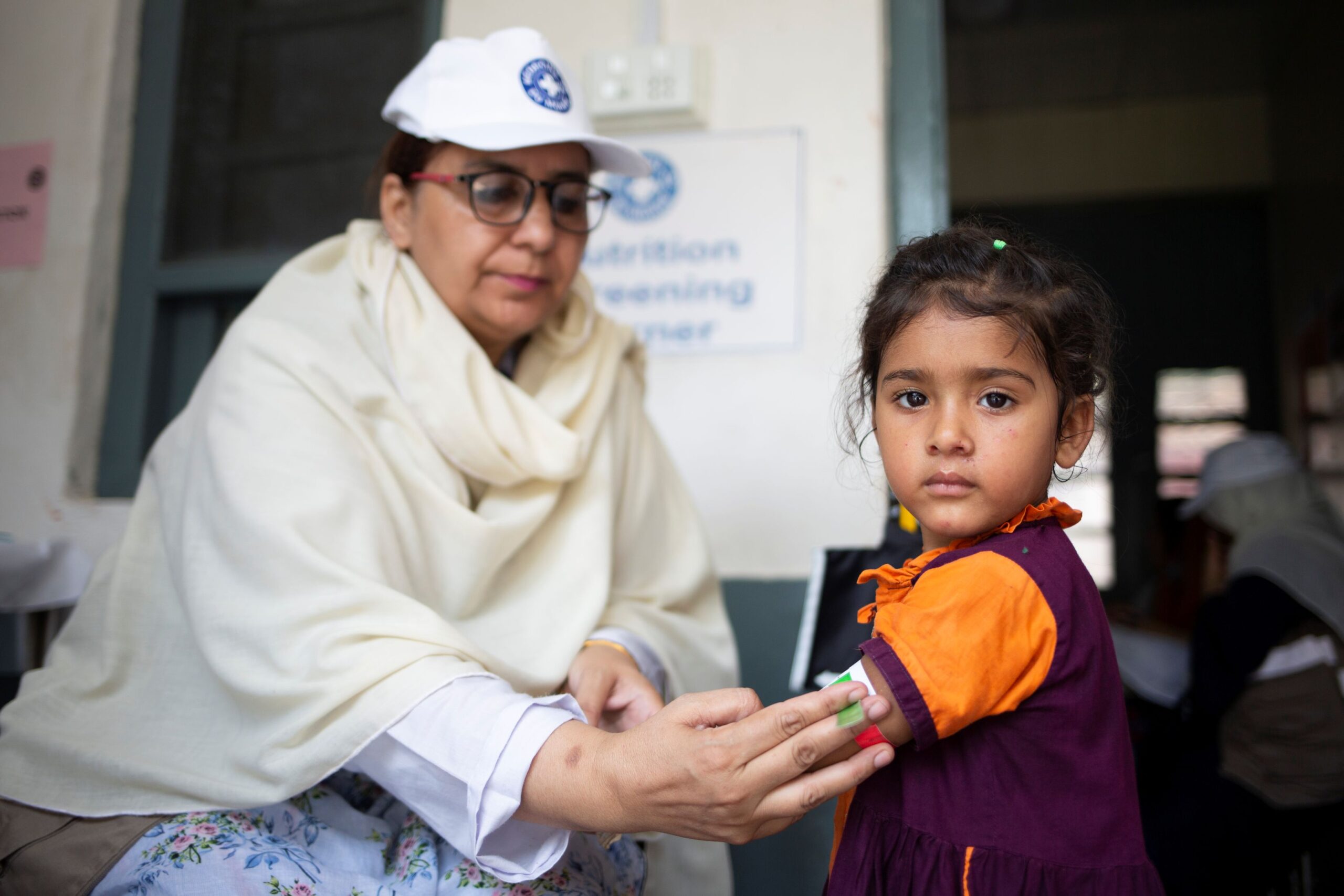 Pakistan: Eine Mitarbeiterin von Ärzte der Welt misst den Armumfang eines kleinen Mädchens. © Saiyna Bashir