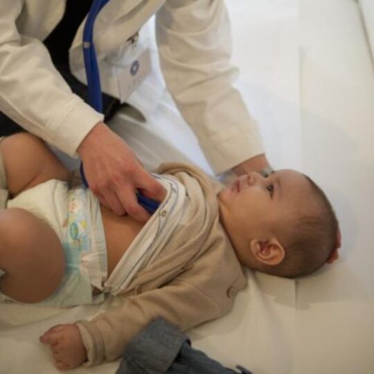 Eine Ehrenamtliche untersucht ein Baby in der open.med-Praxis in München. © Ärzte der Welt