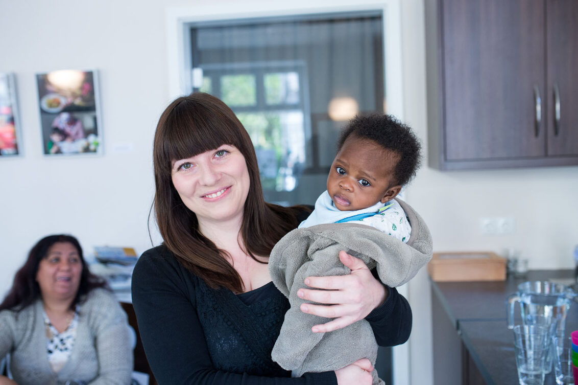 Open.med Sprechstunde in Hamburg: Eine Frau mit einem Baby auf dem Arm. Ärzte der Welt bietet in Deutschland Sprechstunden für Mütter und Kinder an. © Bente Stachowske