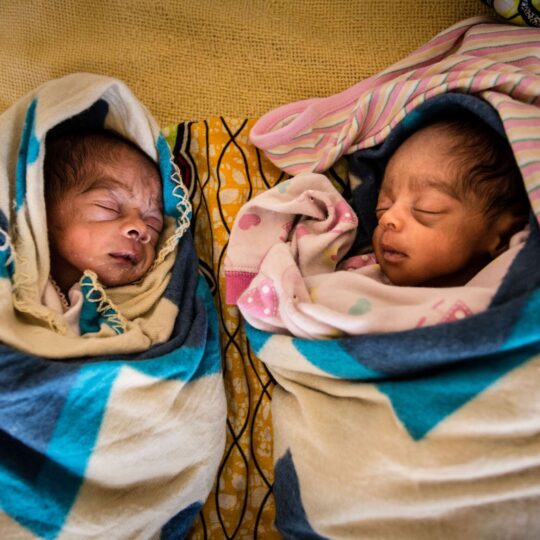 D. R. Kongo: Zwei Babys liegen nebeneinander, in Decken gewickelt. © Kristof Vadino