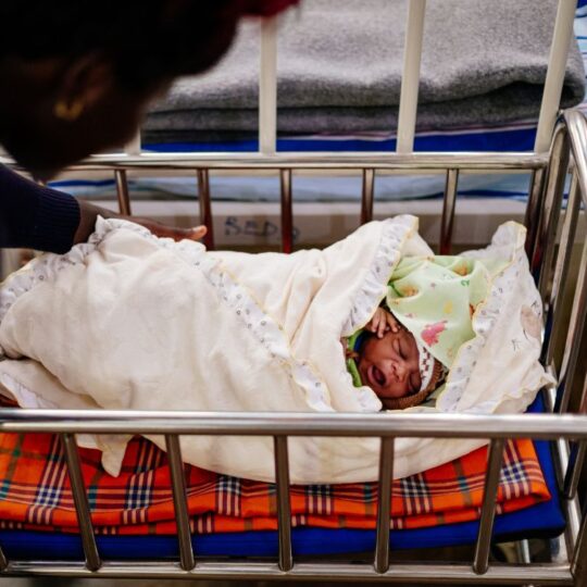 Uganda: Eine Frau beugt sich über ein Neugeborenes in einer Wiege. Ärzte der Welt leistet lebenswichtige Hilfe bei Geburten. © Sébastien Duijndam