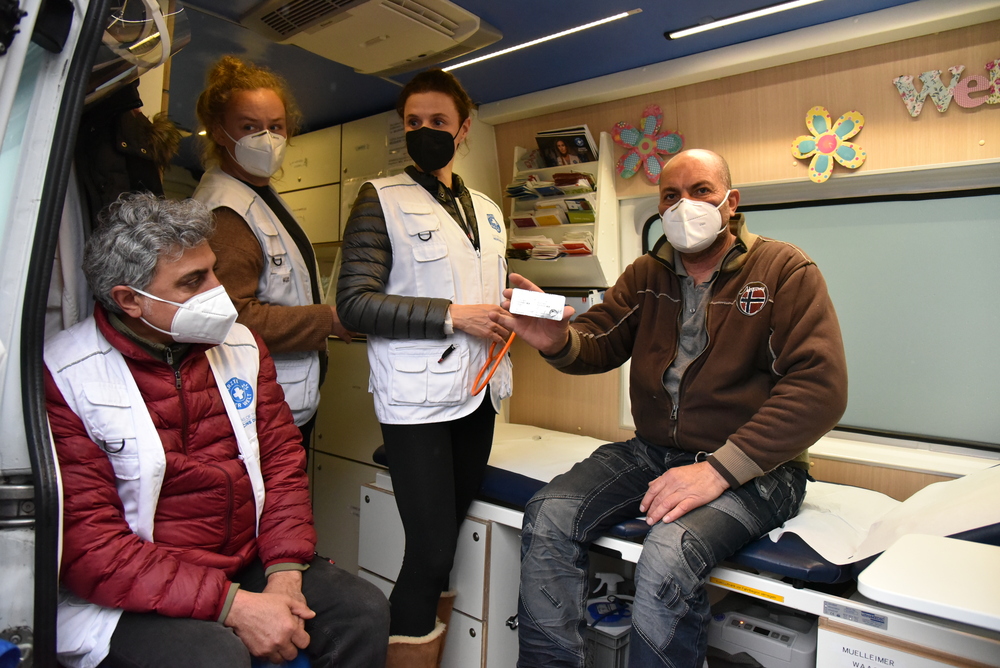 Mitarbeitende von Ärzte der Welt helfen einem Patienten im Behandlungsbus von open.med München.