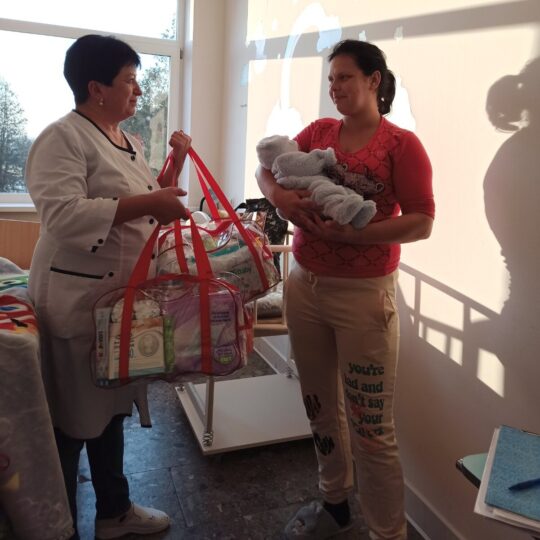 Ukraine: Eine Frau hält ein Baby im Arm, eine andere Taschen. Ärzte der Welt leistet hier medizinische Hilfe. © Ärzte der Welt