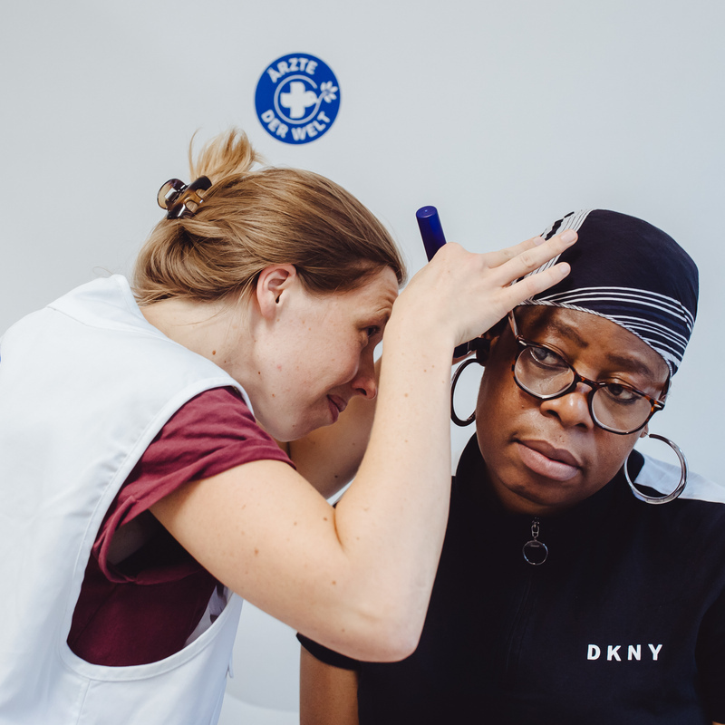 In der Berliner Sprechstunde untersucht eine Ärztin das Ohr einer Patientin. © Max Avdeev