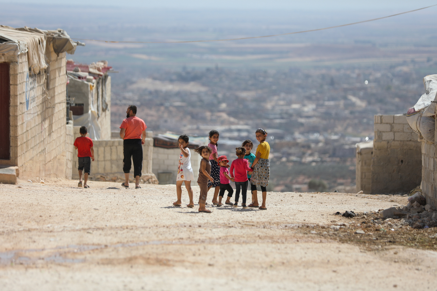 Syrien nach dem Erdbeben 2023: Eine Gruppe von Kindern läuft auf einer Straße, einige lachen und winken in die Kamera. © Ärzte der Welt