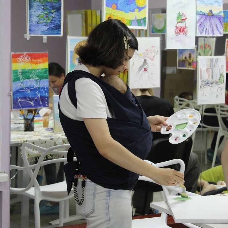 Eine junge Mutter mit ihrem Baby bei einem Mal-Workshop. © Ärzte der Welt 