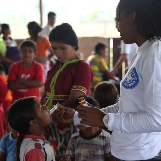 Kolumbien: Eine Mitarbeiterin von Ärzte der Welt verabreicht einem Mädchen ein flüssiges Medikament. © Gilbert Poitiers