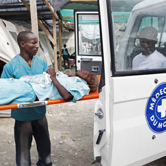 Haiti: Ein Mann wird auf einer Liege in ein Fahrzeug von Ärzte der Welt gebracht. © Lahcene Abib