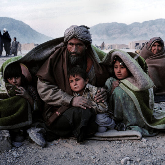 Afghanistan: Erwachsene und Kinder wärmen sich unter einer Decke. © Ärzte der Welt
