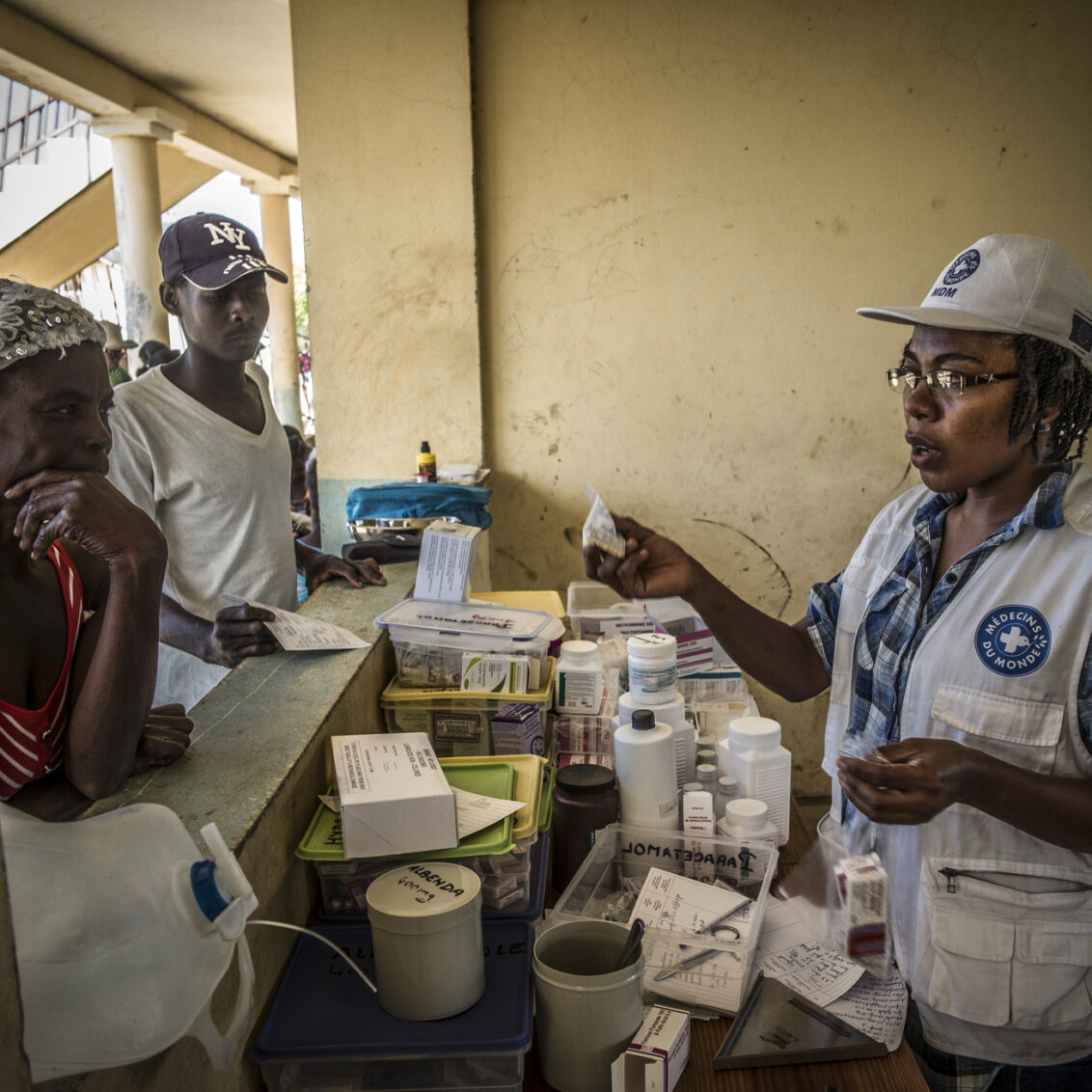 Eine Apothekerin von Ärzte der Welt bedient Menschen aus Haiti und überreicht ihnen Medikamente. © Ärzte der Welt