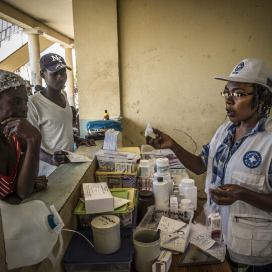 Eine Apothekerin von Ärzte der Welt bedient Menschen aus Haiti und überreicht ihnen Medikamente. © Ärzte der Welt