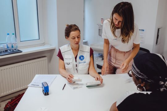 Zwei Helferinnen von Ärzte der Welt in Berlin schauen sich Medikamente für eine Patientin an. © Max Avdeev