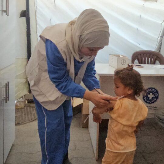 Gaza: Eine Mitarbeiterin von Ärzte der Welt misst den Armumfang eines kleinen Mädchens. © Ärzte der Welt