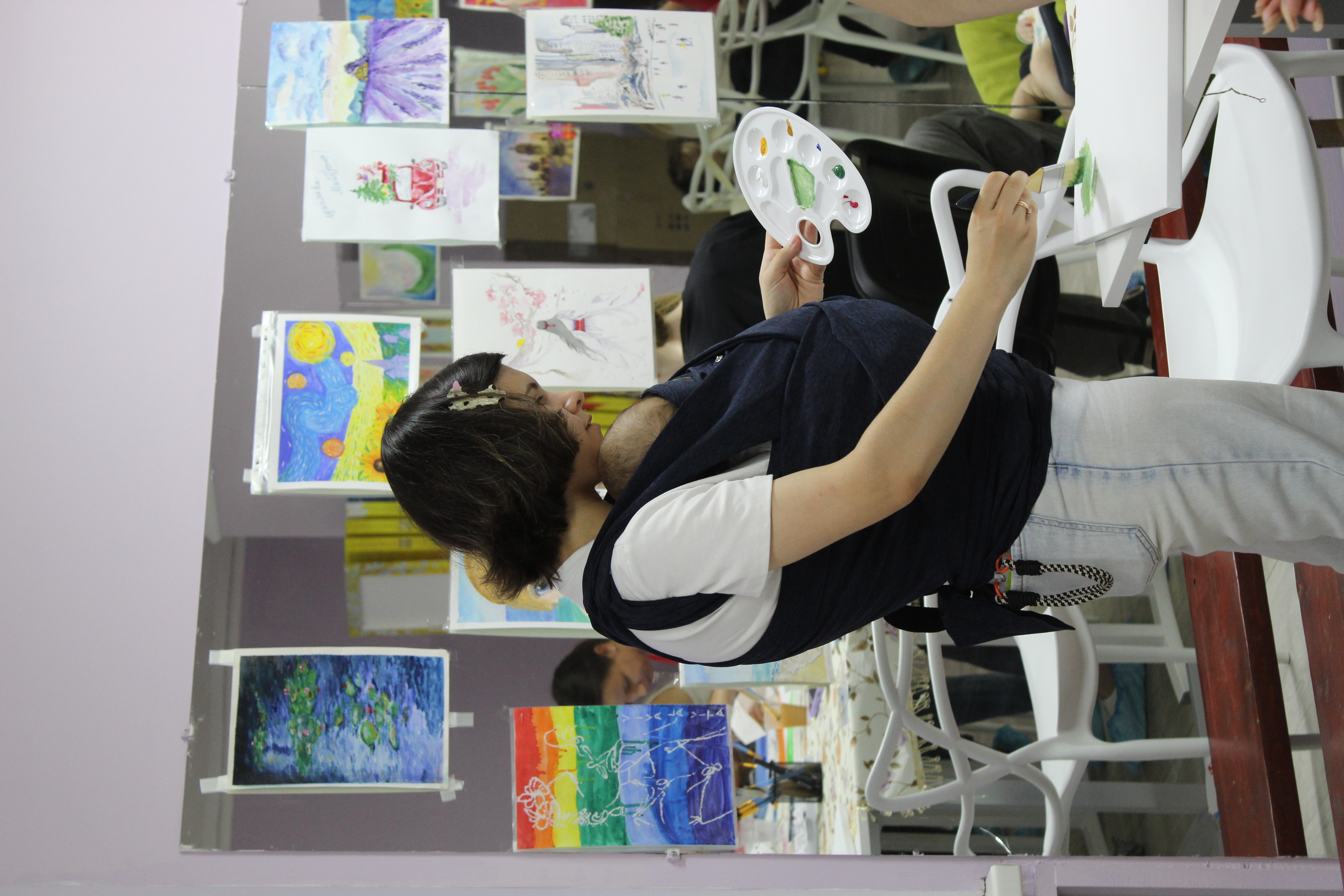 Eine junge Mutter mit ihrem Baby bei einem Mal-Workshop. Foto: Ärzte der Welt