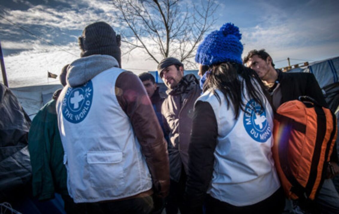 © Olivier Papegnies Menschen stehen in einem Kreis in Calais, Frankreich. © Olivier Papegnies