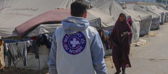 Ein humanitärer Helfer läuft durch eine palästinensisches Flüchtlingslager. Foto: Ärzte der Welt