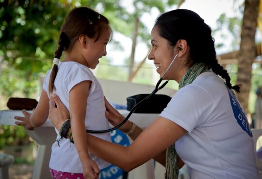 Eine Mitarbeiterin von Ärzte der Welt hört die Atmung eines venezolanischen Mädchens ab. © Elisabeth Rull
