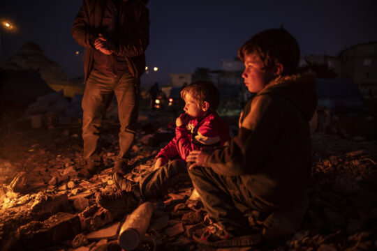 © Olivier Papegnies Kinder, deren Zuhause durch das Erdbeben 2023 an der türkisch-syrischen Grenze zerstört wurde, wärmen sich an einem Holzfeuer in einem provisorischen Lager. © Olivier Papegnies